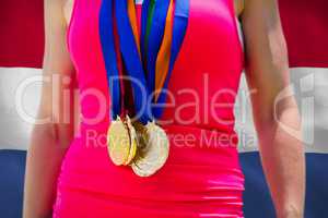 Composite image of portrait of sportswoman chest with medals