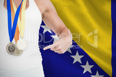Composite image of female athlete pointing her medals