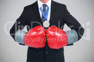 Composite image of businessman with boxing gloves