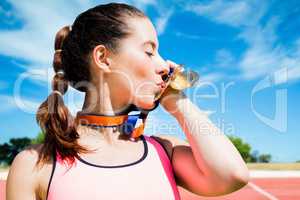 Composite image of portrait of sportswoman kissing her medals