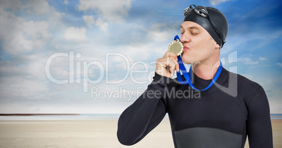 Composite image of swimmer kissing his gold medal