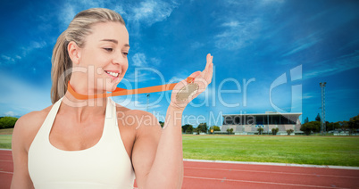 Composite image of female athlete holding medal