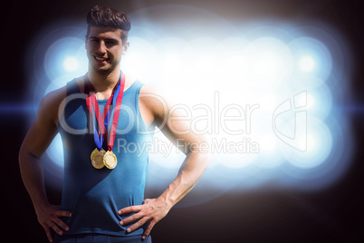 Composite image of portrait of athletic man holding medals