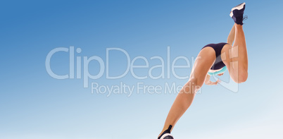 Composite image of low angle female athlete jumping