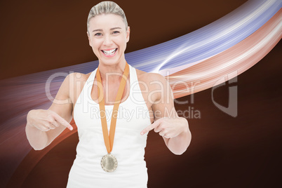 Composite image of female athlete pointing her medal