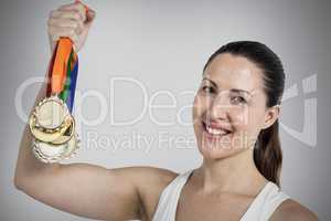 Composite image of female athlete posing with gold medals after