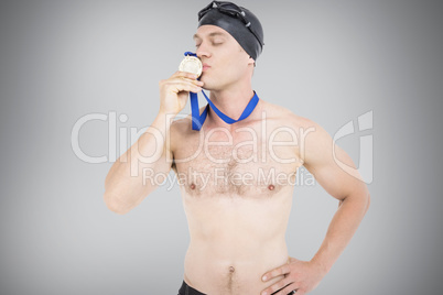 Composite image of swimmer kissing his gold medal