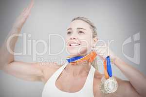 Composite image of female athlete holding medals
