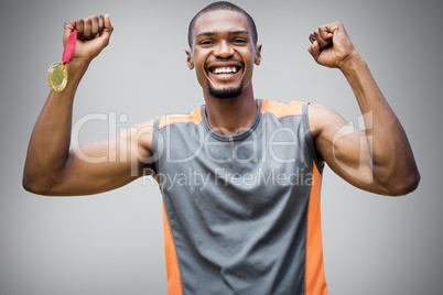 Composite image of happy sportsman smiling and holding medals