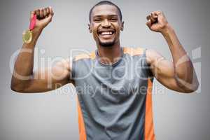 Composite image of happy sportsman smiling and holding medals