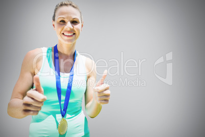 Composite image of portrait of smiling sportswoman holding a med
