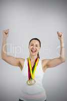 Composite image of female athlete posing with gold medal after v
