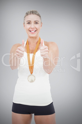 Composite image of female athlete wearing a medal and showing th