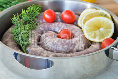 Homemade pork sausage in a frying pan for a roast.