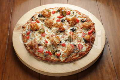 Prawn shrimp flat bread pizza served on a circular wooden board