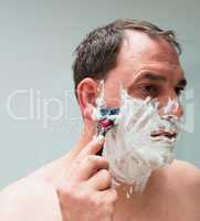 Mann rasiert sich