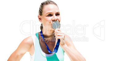 Portrait of sportswoman kissing a medal