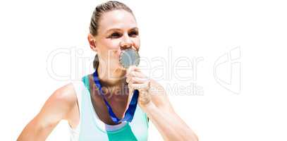 Portrait of sportswoman kissing a medal