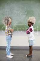Kids wearing wig standing face to face in classroom