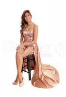 Young woman sitting in prom dress.
