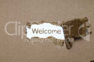 The word welcome appearing behind torn paper.