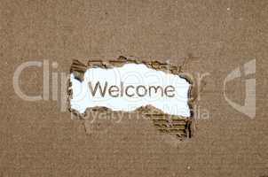 The word welcome appearing behind torn paper.