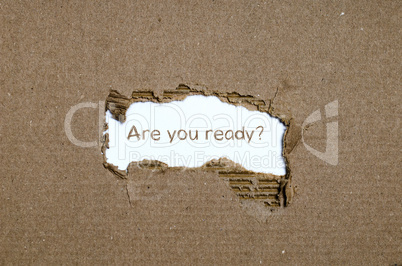 The word are you ready appearing behind torn paper.