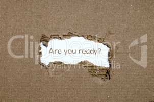The word are you ready appearing behind torn paper.