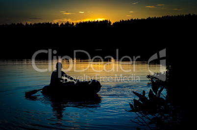 Fisherman in boat at sunset