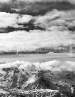 Black and white sunlight snowy mountains in clouds