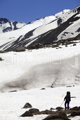 Hiker in snowy mountains at spring
