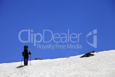 Hiker in snowy mountains at spring