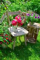 alter Stuhl im Garten mit Blumen