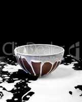 Ceramic bowl and spilled milk in black