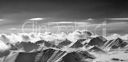Black and white panoramic view on cloudy mountains in evening