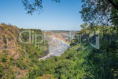 Rainbow spanning gorge beneath Victoria Falls Bridge