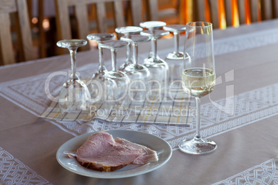 Champagne glass and a cooked ham on a plate