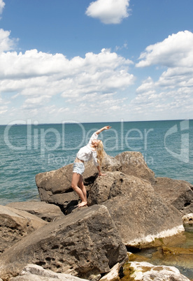 Young woman standing on big rock's