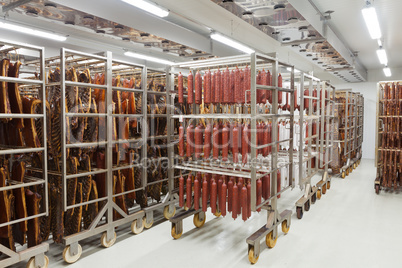 Fresh traditional sausages ready for drying in a smokehouse of a