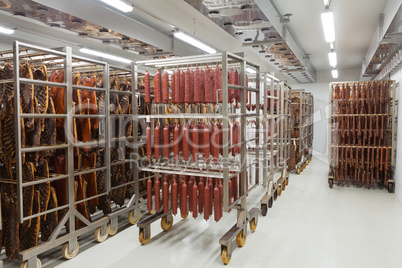 Fresh traditional sausages ready for drying in a smokehouse of a