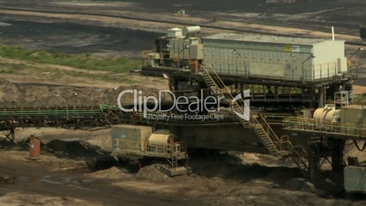 Open-cast mining. Defocus on cabin from flat conveyor. Medium shot. Surface mine.