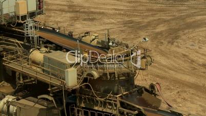 Open-cast mining. Flat conveyor, pan on distribution. Medium shot. Surface mine.