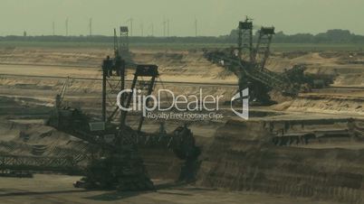 Open-cast mining. Two giant bucket-wheel excavators. Long shot. Surface mine.