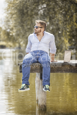 man at the lake with notebook
