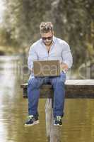 man at the lake with notebook