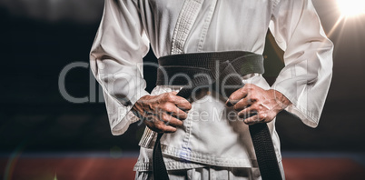 Composite image of fighter tightening karate belt