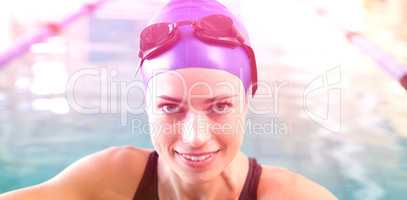 Fit swimmer in the pool smiling at camera