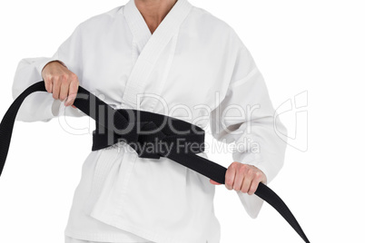 Female athlete tightening her judo belt