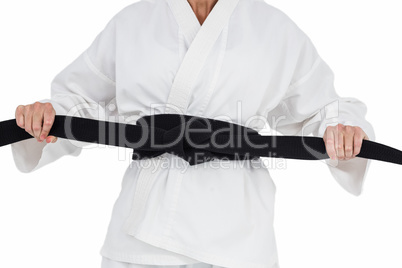 Female athlete tightening her judo belt