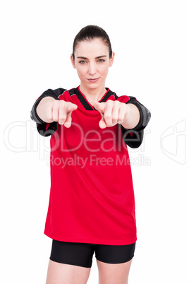 Female athlete posing with elbow pad and pointing the camera